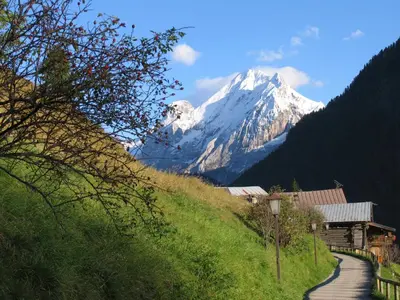 a snow covered mountain in the distance with a path at Chalet Pian in Campitello di Fassa