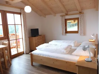 a bedroom with two beds and a desk and windows at Haus Schlernblick in Nova Ponente