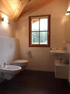 a bathroom with two sinks and a toilet and a window at Haus Schlernblick in Nova Ponente