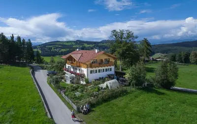 a house on a road next to a green field at Haus Schlernblick in Nova Ponente