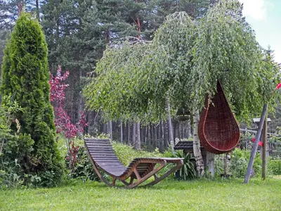 a hammock sitting in the grass under a tree at Haus Schlernblick in Nova Ponente