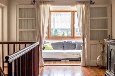 a living room with a couch in front of a window at Rieplhof - Relaxing farm stay with breakfast and mountain view in Vipiteno