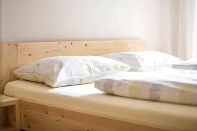 two white pillows sitting on top of a bed at Rieplhof - Relaxing farm stay with breakfast and mountain view in Vipiteno