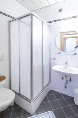 a white bathroom with a shower and a sink at Rieplhof - Relaxing farm stay with breakfast and mountain view in Vipiteno