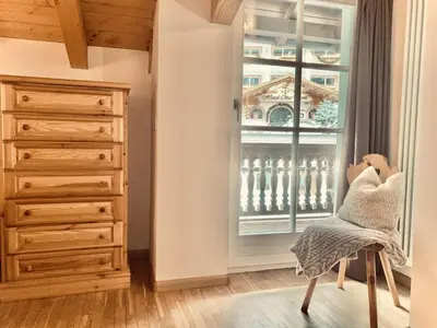 a room with a dresser and a window and a chair at Cesa Cascata in Canazei