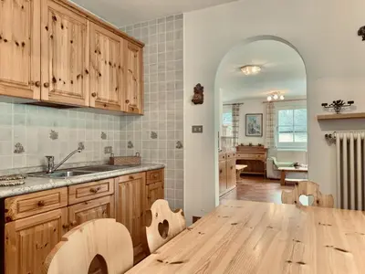 a kitchen with wooden cabinets and a wooden table at Cesa Cascata in Canazei
