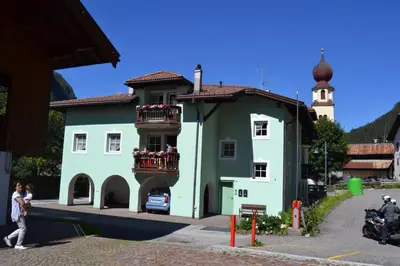 a green building with flowers on the balconies at Cesa Cascata in Canazei