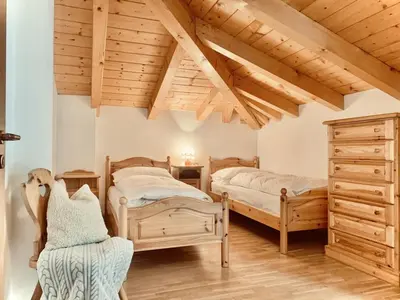 two beds in a bedroom with wooden ceilings at Cesa Cascata in Canazei