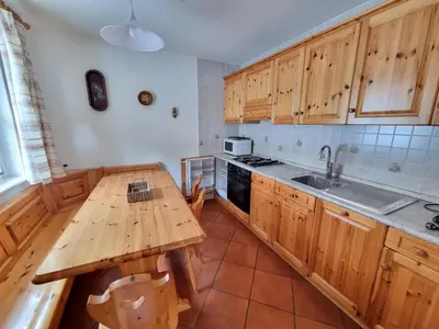 a kitchen with wooden cabinets and a wooden table at Cesa Cascata in Canazei