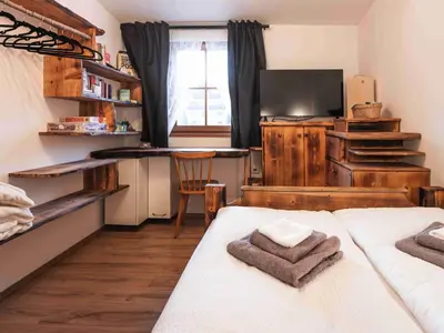 a bedroom with two beds and a desk with a television at Luxury Larch Loft in Tesido