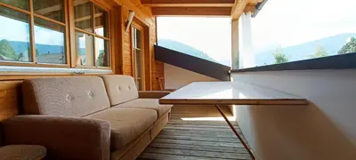 a room with a couch and a table and windows at Luxury Larch Loft in Tesido