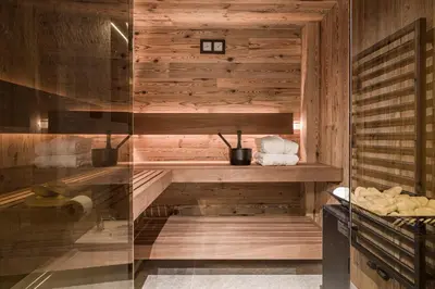 a sauna with wooden walls and a glass door at Stay COOPER I DIAMANTIDI Lodge - Modern Mountain Chalet in the Dolomites in Obereggen