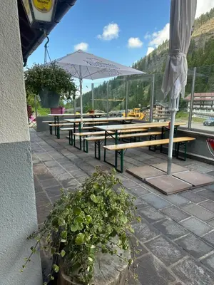 a group of picnic tables with an umbrella at Ski Lodge Pampeago in Tesero