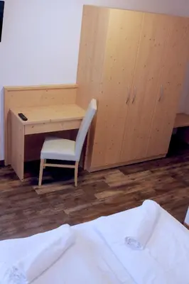 a room with a desk and a chair next to a bed at Ski Lodge Pampeago in Tesero