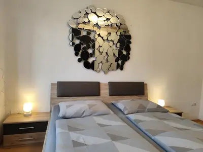 a bedroom with a bed and a chandelier on the wall at Apartment 66 - Modernes Apartment mit Balkon und Parkplatz in Toplage in Brixen in Bressanone