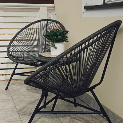 a black chair and a table with a potted plant at Apartment 66 - Modernes Apartment mit Balkon und Parkplatz in Toplage in Brixen in Bressanone