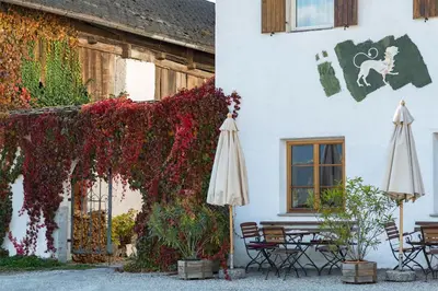a white building with umbrellas and flowers on it at Landhotel Gasthof Zum Löwen in Rodengo
