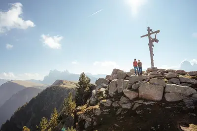 two people standing next to a cross on a mountain at Landhotel Gasthof Zum Löwen in Rodengo