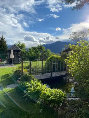 a wooden bridge over a pond in a yard at Landhotel Gasthof Zum Löwen in Rodengo
