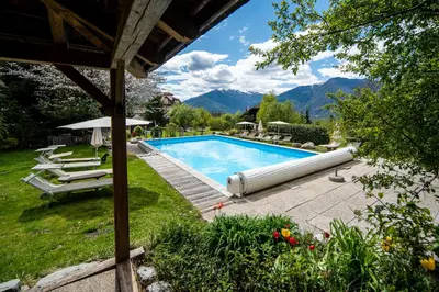 a swimming pool in a yard with mountains in the background at Landhotel Gasthof Zum Löwen in Rodengo