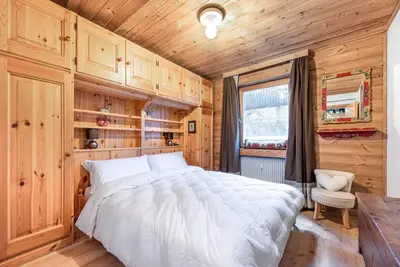 a bedroom with a large bed in a wooden room at Chalet Sassongher II in Corvara in Badia