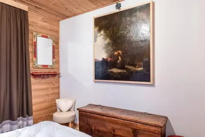 a bedroom with a painting on the wall at Chalet Sassongher II in Corvara in Badia