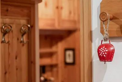 a red lantern hanging on a wall next to a door at Chalet Sassongher II in Corvara in Badia
