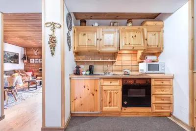 a kitchen with wooden cabinets and a microwave at Chalet Sassongher II in Corvara in Badia