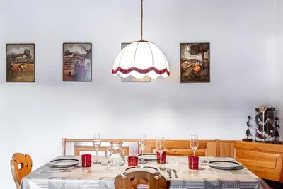 a dining room with a table and a chandelier at Chalet Sassongher II in Corvara in Badia