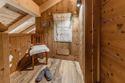 a room with two pairs of shoes in a wooden room at FARM CHALET JUSCIARA in Badia
