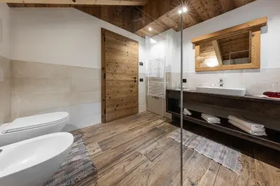a bathroom with a tub and a toilet and a sink at FARM CHALET JUSCIARA in Badia