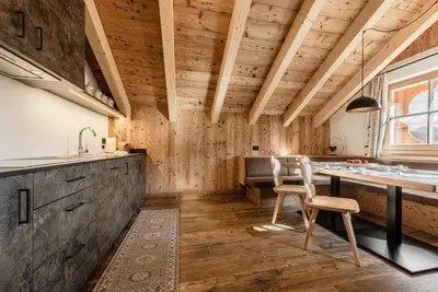 a kitchen with wooden walls and a table and chairs at FARM CHALET JUSCIARA in Badia