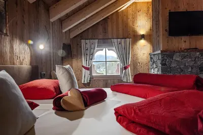 a room with two red beds and a window at FARM CHALET JUSCIARA in Badia