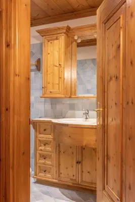 a bathroom with a sink and wooden cabinets at Casa Lacedel 2, on ski slopes in Cortina dʼAmpezzo