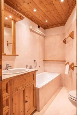 a bathroom with a tub and a sink and a toilet at Casa Lacedel 2, on ski slopes in Cortina dʼAmpezzo