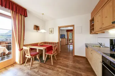 a kitchen with a table and chairs and a dining room at Tommelehof in Lagundo