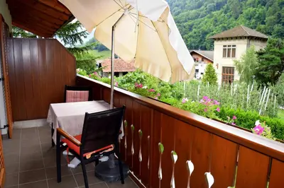 a balcony with a table and an umbrella at Tommelehof in Lagundo