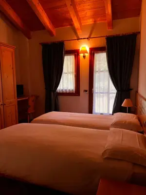 a bedroom with two beds and two windows at Agriturismo Busa dei Sbrase in San Cipriano