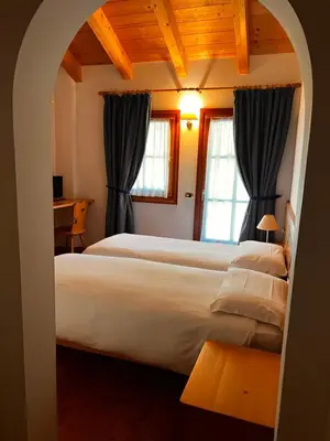 a bedroom with two beds and two windows at Agriturismo Busa dei Sbrase in San Cipriano