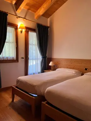 a bedroom with two beds and a window at Agriturismo Busa dei Sbrase in San Cipriano