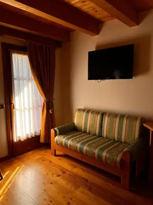 a living room with a couch and a flat screen tv at Agriturismo Busa dei Sbrase in San Cipriano