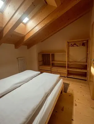 a bedroom with a large bed and wooden ceilings at Maso Alpino con vista sulle Dolomiti in Mendola