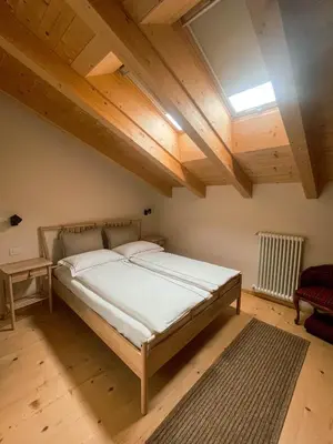 a bedroom with a bed and a wooden ceiling at Maso Alpino con vista sulle Dolomiti in Mendola