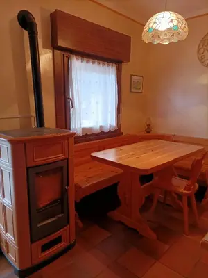a kitchen with a wooden table and a stove at La tua piccola casa a Pecol in Mareson
