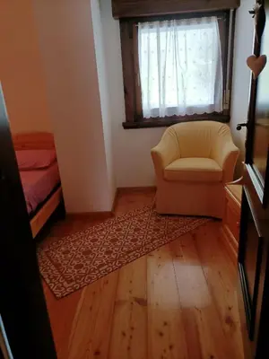 a living room with a chair and a window at La tua piccola casa a Pecol in Mareson