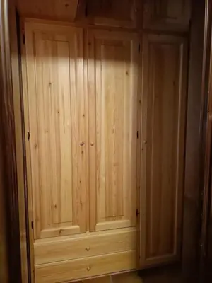 a wooden cabinet with two doors in a room at La tua piccola casa a Pecol in Mareson