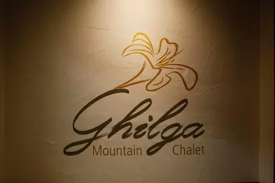 a sign for a restaurant with a flower on a wall at Mountain Chalet Ghilga in Ortisei