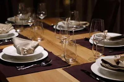 a wooden table with plates and wine glasses on it at Mountain Chalet Ghilga in Ortisei