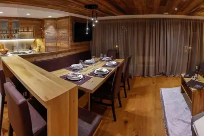 a dining room with a long wooden table and chairs at Mountain Chalet Ghilga in Ortisei