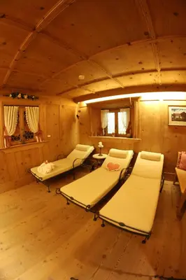 a room with beds and a table in a cabin at Hotel Val in Selva di Val Gardena